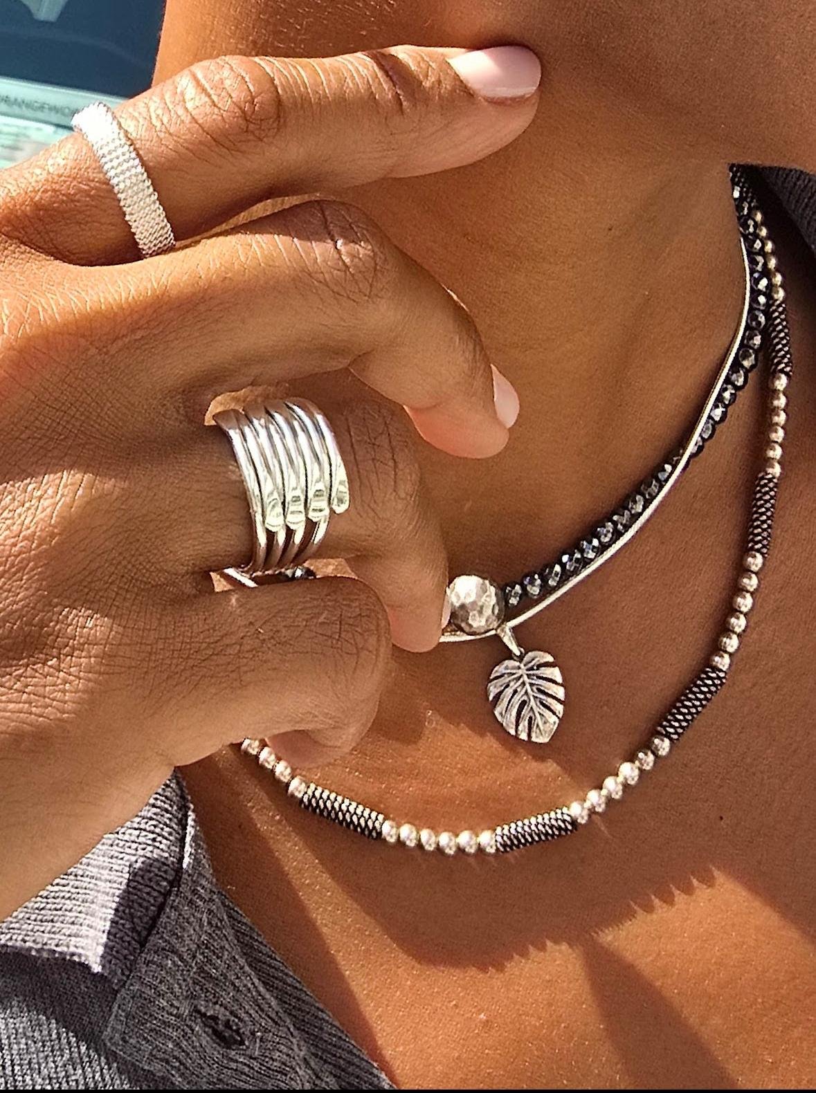 A model wearing Vivi Vie sterling silver rings and layered necklaces